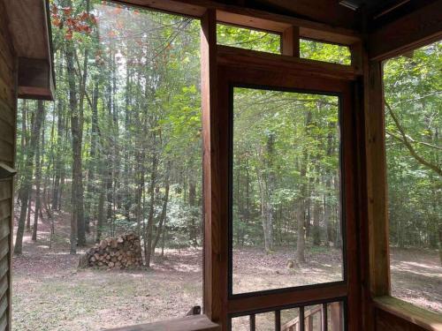 a window in a cabin looking out at a forest at Private cozy cabin in the woods with great view in Murphy