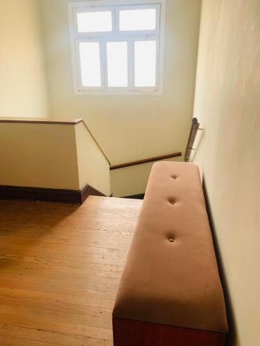 a brown bench in a room with a window at Peruvian House - Miraflores in Lima
