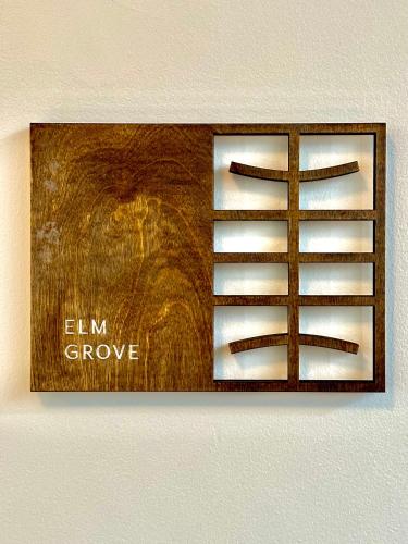a wooden sign on a wall with the words elm grove at CoHouse New Haven steps to Yale University in New Haven
