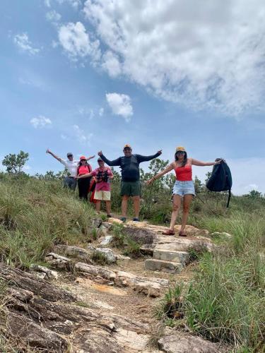 a group of people standing on a hill with their arms out at Pousada Filhos da Canastra in Vargem Bonita