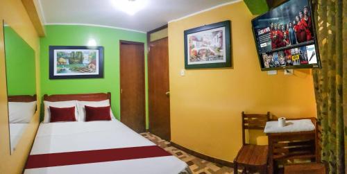 1 dormitorio con 1 cama con paredes de color verde y amarillo en Hospedaje Escorpio, en Lima