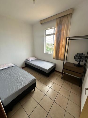 a bedroom with two beds and a window at Pampulha 2 quartos completo in Belo Horizonte