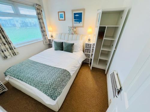 ein kleines Schlafzimmer mit einem Bett und einem Fenster in der Unterkunft 2 Bedroom Chalet SB109, Sandown Bay, Isle of Wight in Brading