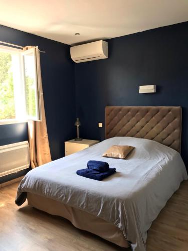 une chambre avec un grand lit aux murs bleus dans l'établissement Jolie villa à Grasse quartier Saint Antoine, à Grasse