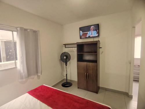 a bedroom with a bed with a television on the wall at Estúdios VILA 5 - Executive, próx Congresso, Tribunais, Embaixadas in Brasilia