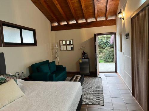 ein Wohnzimmer mit einem Bett und einer Couch und einer Tür in der Unterkunft Cottage Refuge in Rionegro