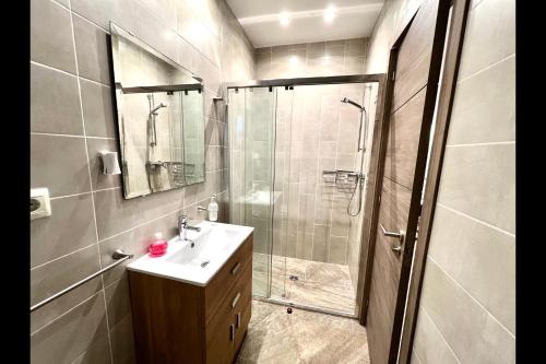 y baño con ducha, lavabo y espejo. en Mijas Costa - Beachside Apartment-2, en La Cala de Mijas