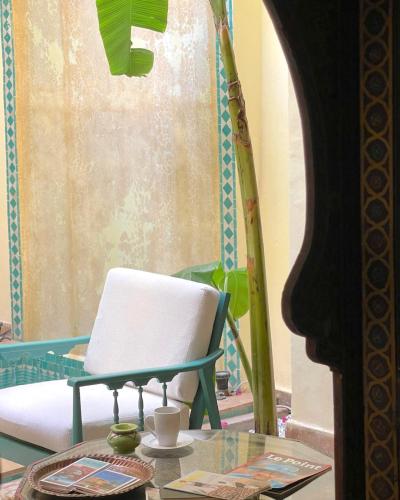 a room with a chair and a glass table at RIAD DAR NAOMI in Marrakech
