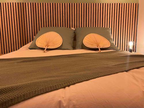 a bed with two pillows at La Cosy Green Suite in Colombelles