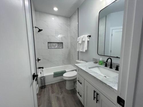 y baño con lavabo, aseo y espejo. en Bywater St Claude area with New Orleans charm! 3 miles from the French Quarter, en Nueva Orleans