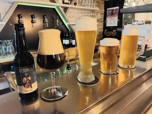 drie glazen bier zittend op een bar bij Room&Breakfast Al Canyon in Fondo