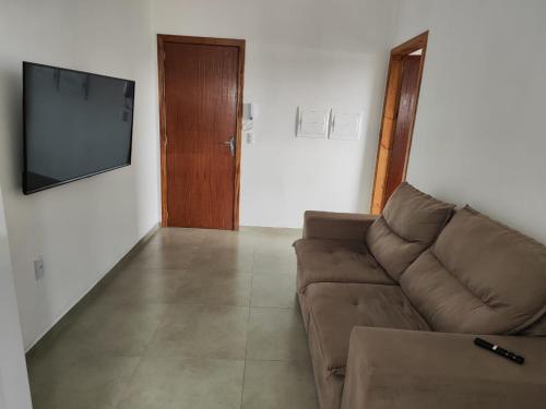 a living room with a couch and a flat screen tv at Apartamento de 1 quarto próximo a 101 in Itajaí