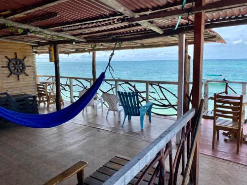 a hammock on a house with a view of the ocean at Raw KokoMar PosadaNativa in Baru