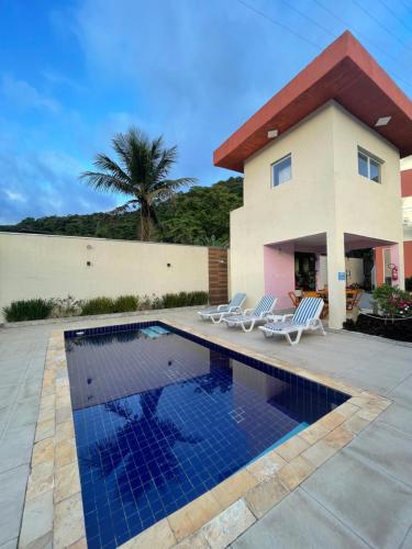 a house with a swimming pool in front of a house at Residencial 220 Maresias in Maresias