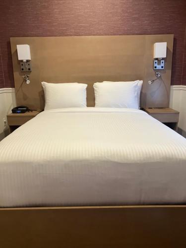 a large bed with white sheets and pillows at The Mayfair Hotel Times Square, an Ascend Collection in New York