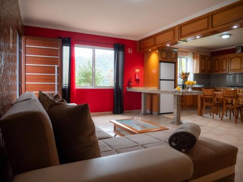 a living room with a couch and a kitchen at The House of Passos in Ponta do Sol