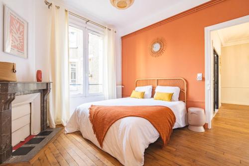 - une chambre avec des murs orange et un lit avec des oreillers jaunes dans l'établissement Champagne Central - Exceptionnel 3 chambres, à Reims