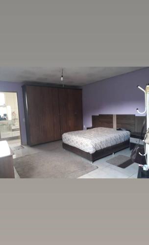 um quarto com uma cama e uma parede roxa em Sítio casa grande em São Gonçalo do Amarante