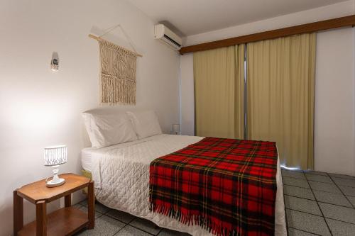 - une chambre avec un lit et une couverture tressée dans l'établissement Apartamento rústico e confortável a 200m do mar - PSD204, à Florianópolis