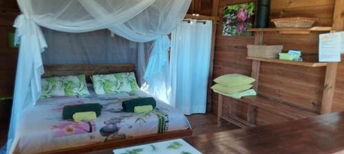 a bedroom with a bed and a table in it at Ma cabane in Deshaies