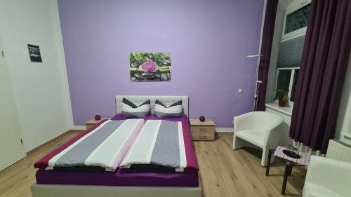 1 dormitorio con cama y pared púrpura en Fewo Kaiser Wohnung Stella, en Dresden