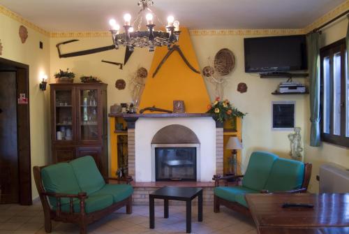 sala de estar con chimenea y sillas verdes en Azienda Agrituristica Salella en Salento