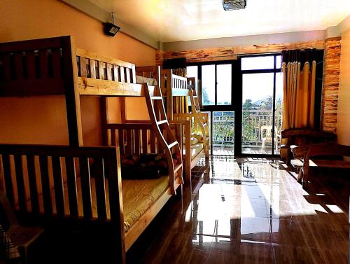 1 Schlafzimmer mit 2 Etagenbetten und einem großen Fenster in der Unterkunft Ilob Transient House in Banaue