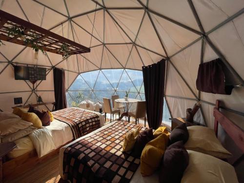 Poas Volcano Observatory Lodge & Glamping في Poasito: غرفة بسريرين في خيمة القبة