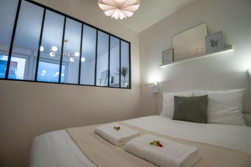 ランスにあるLa verrière Rémoiseのベッドとタオル2枚のある寝室