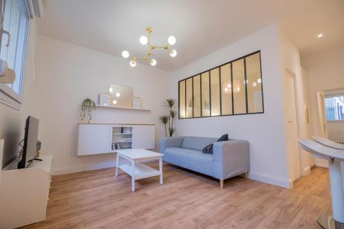 ランスにあるLa verrière Rémoiseの青いソファとテーブルのあるリビングルーム