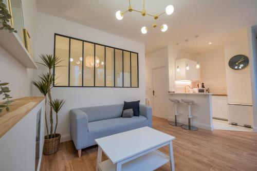 un salon avec un canapé bleu et une table dans l'établissement La verrière Rémoise, à Reims