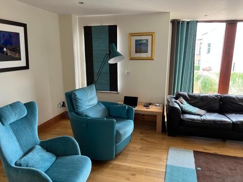 uma sala de estar com duas cadeiras e um sofá em East Belfast Townhouse em Belfast