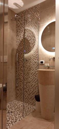 a bathroom with a glass shower and a sink at Dimora Cleó in Putignano
