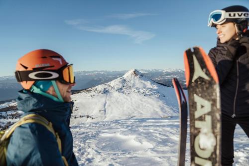 two people standing on top of a mountain with skis at Michlhaus nature and suites in Aldino