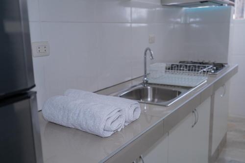 a white kitchen with a sink and a towel at Suite and Business in Pucallpa