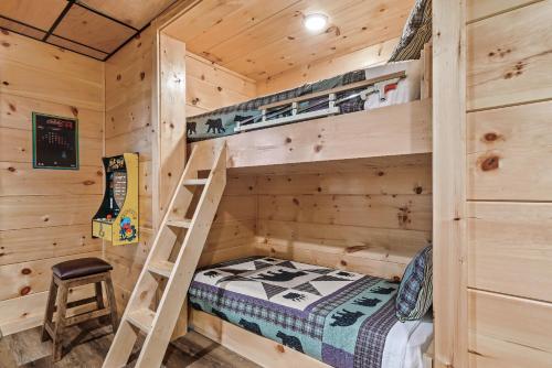 a wooden cabin with a bunk bed and a ladder at Mountains r Calling, Cozy Hideaway, King Beds, Hot-Tub, Arcade, EV Ready in Pigeon Forge