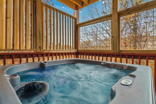 a jacuzzi tub in a wooden house at cul-de-sac Cabin on Parkway, 2King Beds & Bunk Beds, Hot Tub, Arcade Games in Pigeon Forge