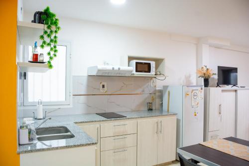 cocina con fregadero y nevera blanca en Centro Apart Home en Jesús María