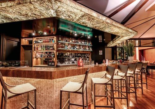 a bar with a row of stools in a restaurant at Apart-hotel Bourbon São Paulo Ibirapuera Convention Hotel in Sao Paulo