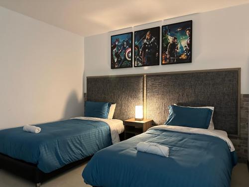 a bedroom with two beds with blue comforters at Beta Hotel in Salento