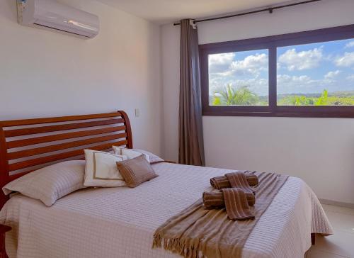 a bedroom with a bed with a large window at Porto Serra Mar Flats Praia de Sibaúma- Pipa in Tibau do Sul