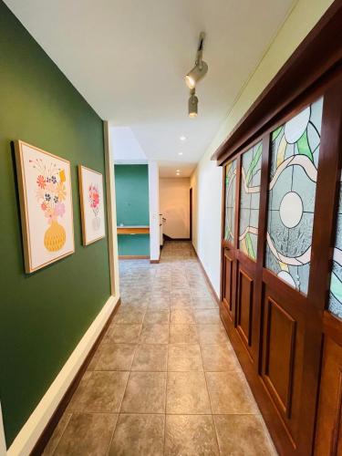 a hallway with green walls and a door with stained glass at The Rainier Bed & Breakfast 5 in San José