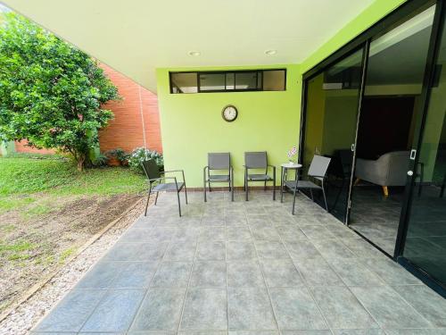 a patio with chairs and a clock on a wall at The Rainier Bed & Breakfast 5 in San José