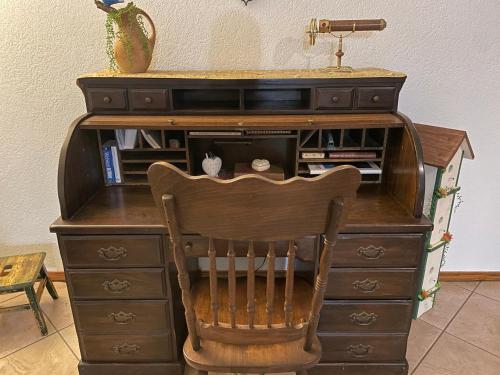 a wooden desk with a chair in a room at Cozy house centrally located close to everything in NWA in Springdale