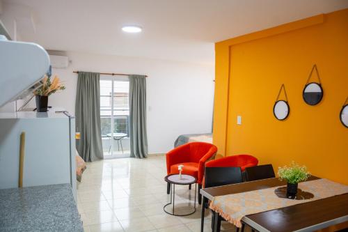 a living room with red chairs and a yellow wall at Centro Apart Home in Jesús María