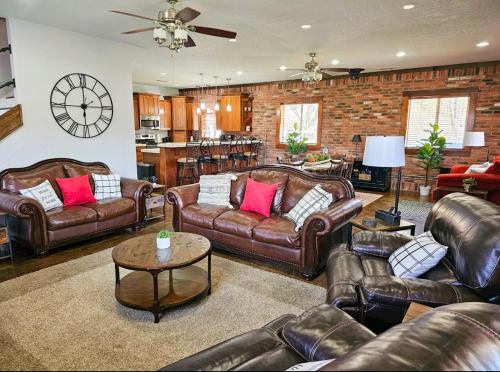 a living room with leather couches and a brick wall at Beaver Lake Hideaway in Lowell
