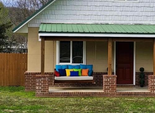 a porch of a house with a bench with pillows at Beaver Lake Hideaway in Lowell
