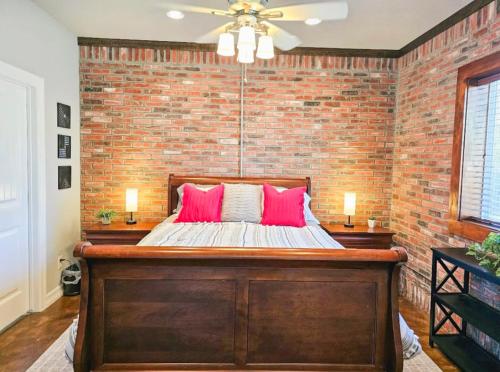 a brick walled bedroom with a bed with pink pillows at Beaver Lake Hideaway in Lowell
