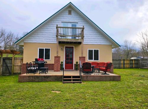 a house with a deck and chairs in the yard at Beaver Lake Hideaway in Lowell