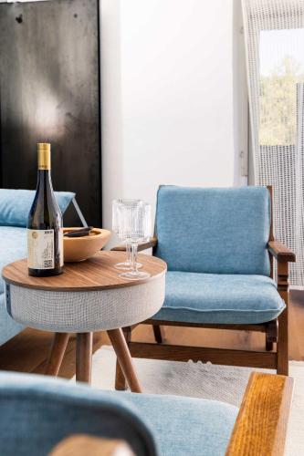 a bottle of wine on a table next to a chair at Michlhaus nature and suites in Aldino